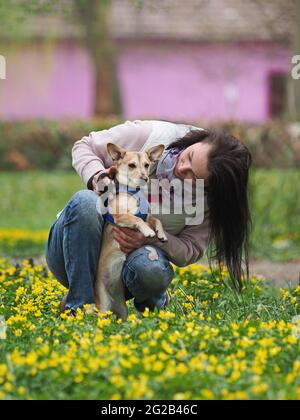 adult nice woman walks the small dog in springtime Stock Photo