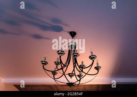 The chandelier casts a shadow on the ceiling Stock Photo