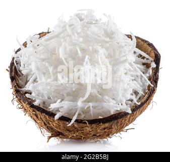 Shredded coconut flakes in the piece of coconut shell isolated on white background. Close-up. Stock Photo