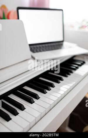 Coronavirus. Quarantine. Online piano music learning with a laptop, education and remote work.  Stock Photo