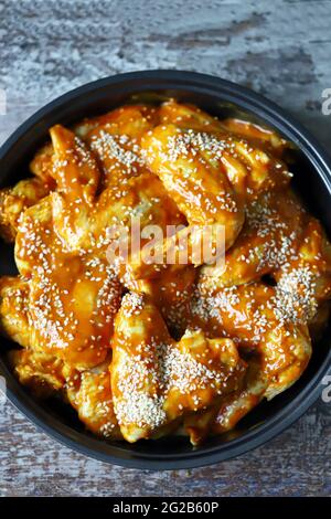 Raw chicken wings marinated in a frying pan before cooking. Stock Photo