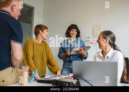 business team working together in startup office. Entrepreneurs in office discussing work strategy. Stock Photo