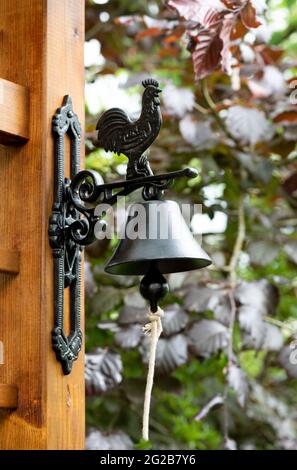 Outdoor interior with wooden fence and metal bell in the garden, Stock Photo