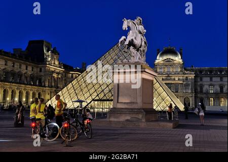 FRANCE, PARIS (75) 1ST ARRONDISSEMENT, THE LOUVRE MUSEUM AND THE PYRAMID AT NIGHT, BIKE TOUR WITH TOURIST GUIDE Stock Photo