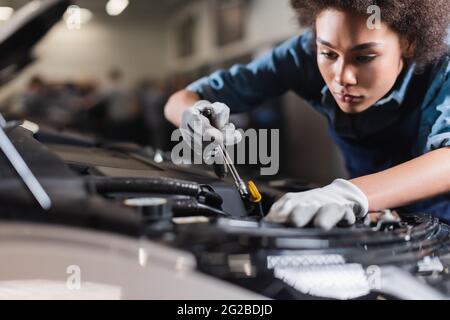 young african american mechanic working with motor of car in garage Stock Photo