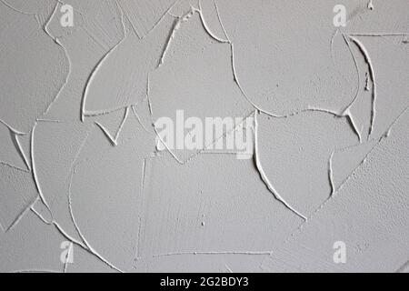 white textured background of filler paste applied with putty knife in irregular dashes and strokes Stock Photo