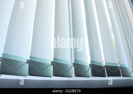 Closed vertical blinds against the background of the window Stock Photo
