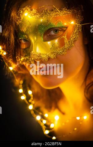 Charming woman in Venetian mask looking at camera Stock Photo