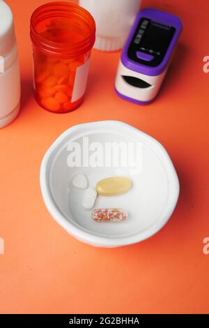 Close up of medical pills and capsules in a small container  Stock Photo