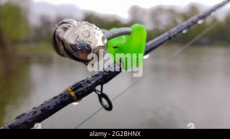 Silver fishing bells are worn on a fishing rod while fishing. Bite-call  signal, at the tip of the rod. A bite alarm will alert you to a bite.  Fishing Stock Photo 