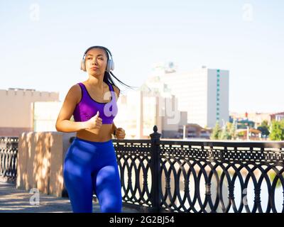 Asian woman running early in the morning. Attractive looking woman keeping fit and healthy. Healthy lifestyle concept. Stock Photo