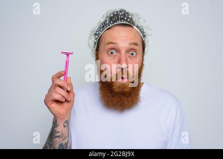 amazed man adjust the beard with a razor blade Stock Photo
