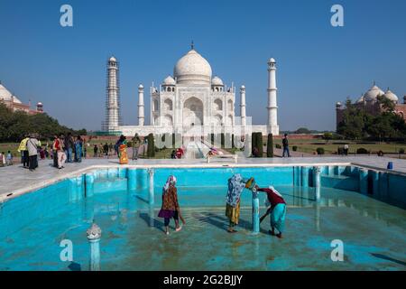 Female workers in process of cleaning one of the pools in Taj Mahal complex as monument opens for public after first covid-19 wave in India. Stock Photo