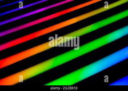 Neon rainbow strips on dark background. Soft focus Abstract rainbow color wave strips horizontal background. Stock Photo