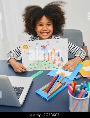 Creative little girl drew a picture with pencils and is very happy with her success. Drawing and creativity lesson. Child development Stock Photo