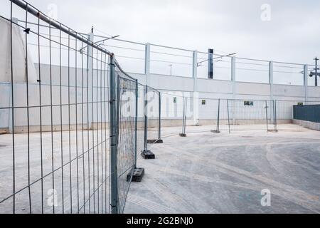 Valencia, Spain - June 9, 2021: Temporary walls and metal fences separate a new industrial construction zone. Stock Photo