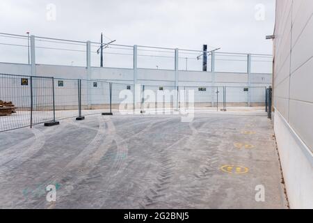 Valencia, Spain - June 9, 2021: Temporary walls and metal fences separate a new industrial construction zone. Stock Photo
