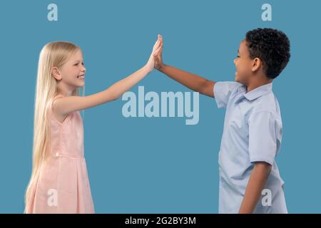 Boy and girl with outstretched hand touching palms Stock Photo