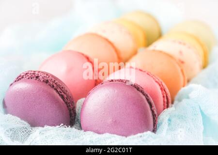 Box of fresh colorful french macarons. Shallow depth of field with selective focus on center macarons. Stock Photo