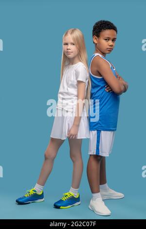 Friends in sportswear with backs to each other Stock Photo