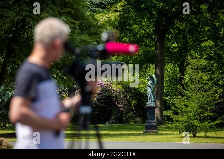 Hanover, Germany. 10th June, 2021. A cameraman films before the start of the funeral of a murder victim in front of the city cemetery Stöcken. On 03.06.2021 there was an altercation between the occupants of two cars on the open street in Hanover, in the course of which a man was killed. Credit: Moritz Frankenberg/dpa/Alamy Live News Stock Photo