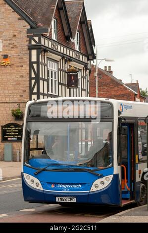 Bus at a bus stop in the market town of Bolsover with The Cavendish pub in the background, Derbyshire, England.