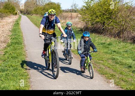 A father and his two young sons cycling along the York Solar System Trail near Escrick, North Yorkshire, England UK Stock Photo