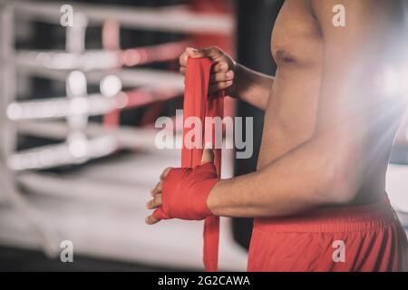 Kickboxer typing a bandage on his hand before the workout Stock Photo