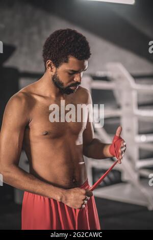 Kickboxer typing a bandage on his hand before the workout Stock Photo