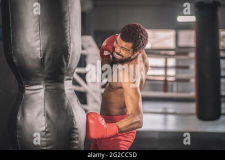 African american kickboxer exercising in a gym working on his kicks Stock Photo