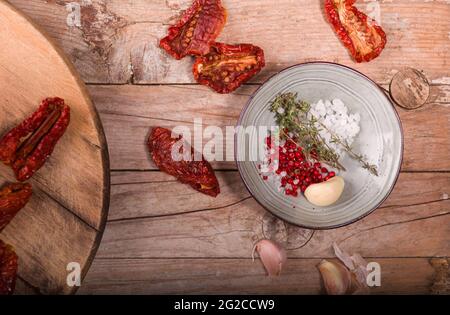 Top view of Mediterranean dried tomatoes, garlic,  and spices on wooden table Stock Photo