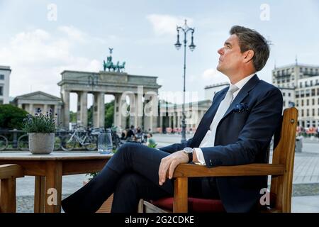 10 June 2021, Berlin: Michael Sorgenfrey, director of the Hotel Adlon Kempinski at Pariser Platz, sits on the terrace in front of the hotel. Starting tomorrow, hotels will be able to receive regular guests again. Photo: Carsten Koall/dpa Stock Photo