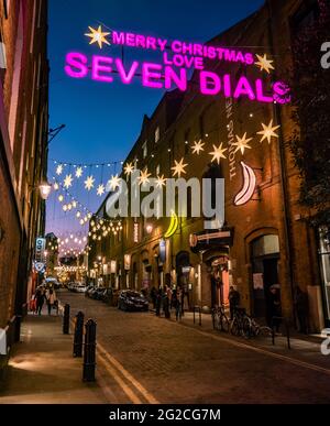 Seven Dials at Christmas, London. A night view of shoppers and the bright Christmas lights in the gentrified fashionable shopping district. Stock Photo