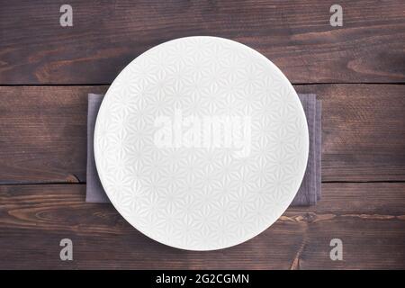 Empty white plate on wooden rustic background. Top view with copy space Stock Photo