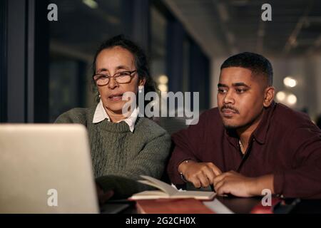 Man and woman in office at night Stock Photo