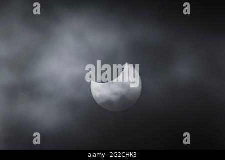 Greystones, co. Wicklow, Ireland. 10th June 2021. The partial solar eclipse “Ring of Fire” viewed between breaks in the clouds at maximum phase. Stock Photo