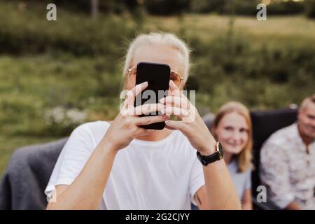 Woman photographing during garden party Stock Photo