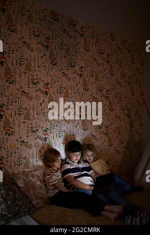 Boys using digital tablet on bed Stock Photo