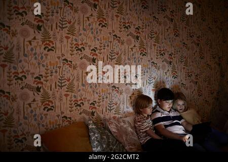 Boys using digital tablet on bed Stock Photo