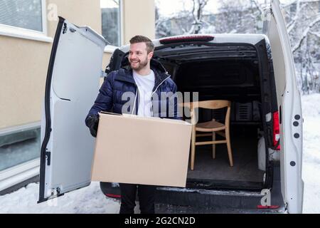 Smiling man carrying cardboard box Stock Photo