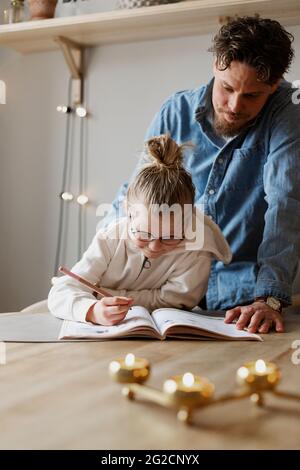 Father helping daughter doing homework Stock Photo