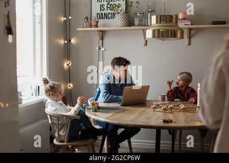 Father sitting with children at table Stock Photo