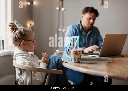 Girl using digital tablet, father in background Stock Photo