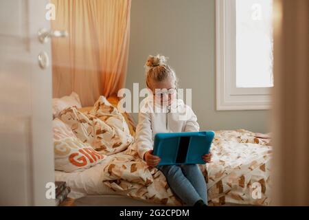 Girl on bed using digital tablet Stock Photo