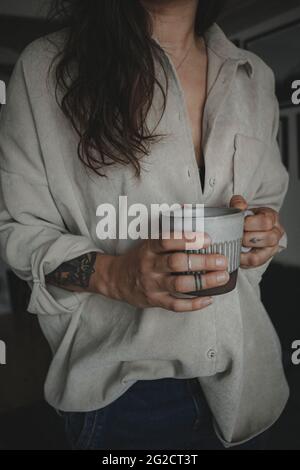 Woman holding mug, mid section Stock Photo