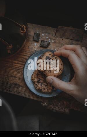 Hand holding chocolate chip cookie Stock Photo