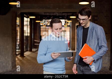 Businessmen standing outdoors and using tablet Stock Photo
