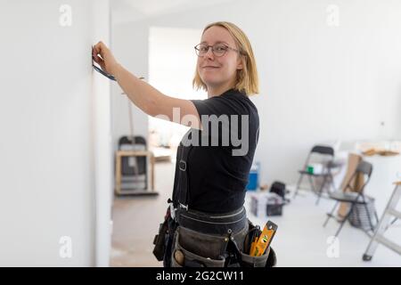 Female electrician renovating house Stock Photo