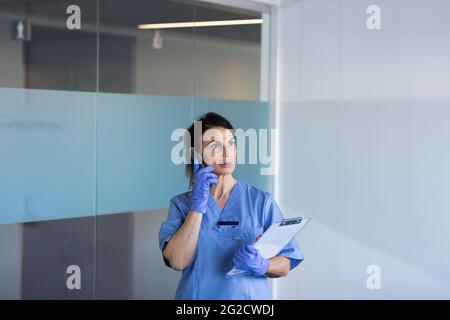 Female nurse talking on phone Stock Photo