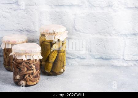 Preservation of vegetables in banks. Fermentation products. Harvesting cucumbers and mushrooms for the winter. Copy space Stock Photo